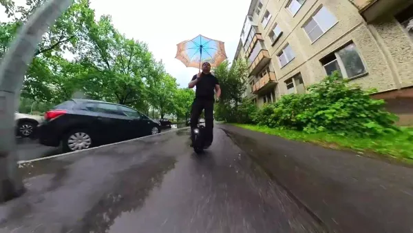 На моноколесе в дождь с зонтом